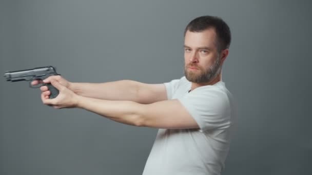 Bilder på en ung man med skägg och pistol — Stockvideo