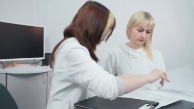 İki işçi ofiste çalışmayı tartışıyor.