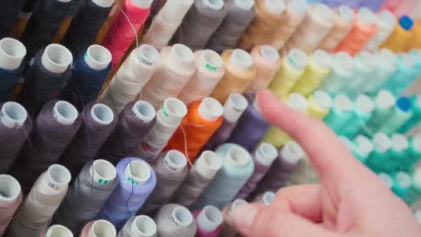 Video de mujer eligiendo carrete de colores de los hilos — Vídeo de stock