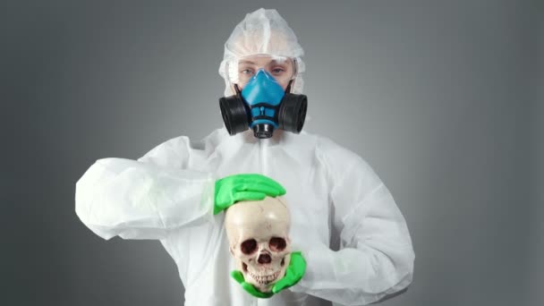 Footage of doctor in protective suit showing skull — Stock Video