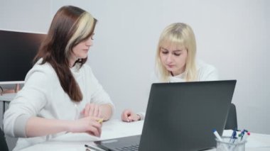 Ofiste iş tartışan iki iş kadını videosu.