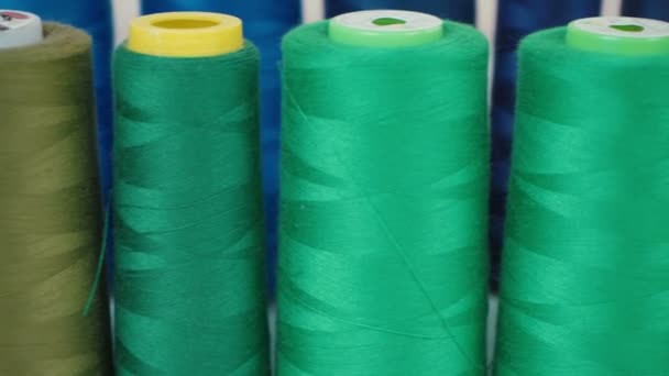 Tournage de bobines vertes de fils en atelier 