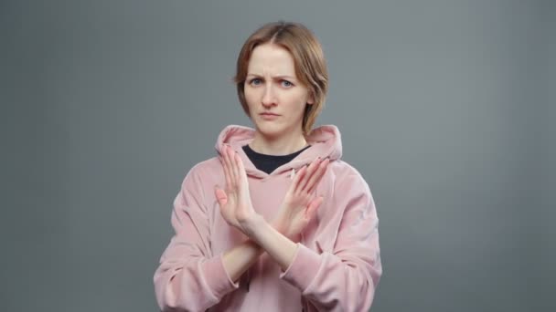 Видео молодой женщины в розовой толстовке, показывающей стоп-жест — стоковое видео