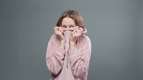 Video von junger versteckter Frau in rosa Sweatshirt — Stockvideo