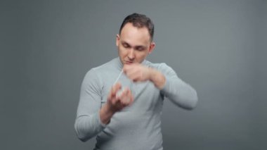 Gri balıkçı yakalı genç adamın maske taktığı bir video.