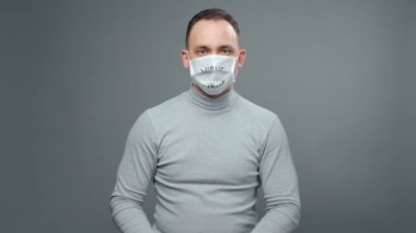 Gri balıkçı yakalı adam tıbbi maske takıyor.