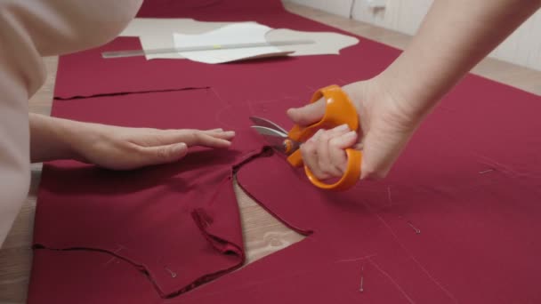 Shooting of seamstress cutting pattern on fabric in workshop — Stock Video