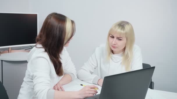 Две женщины обсуждают работу в офисе — стоковое видео