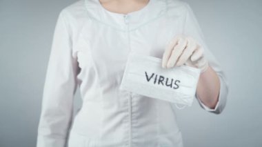 Doktorun elinde tıbbi maske ve ampul tutarken görüntüsü