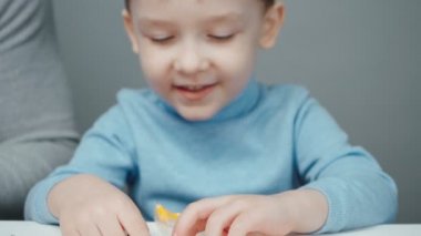 Baba ve küçük çocuk plastikten hayvan yontuyorlar.