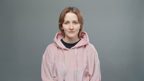 Video van jonge serieuze vrouw in roze sweatshirt — Stockvideo