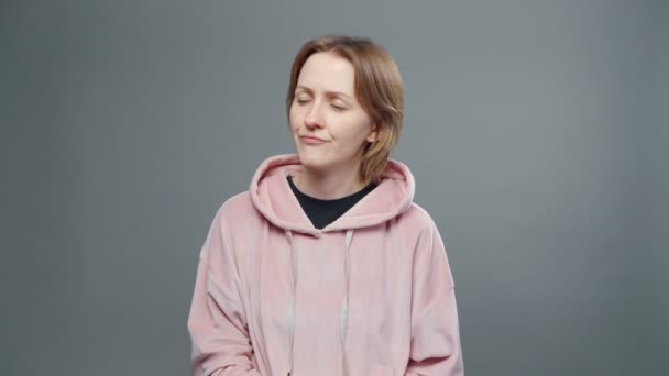 Shooting of young thoughtful woman in pink sweatshirt — Stock Video