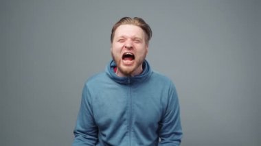 Mavi kazaklı, kızgın sarışın bir adamın vurulması.