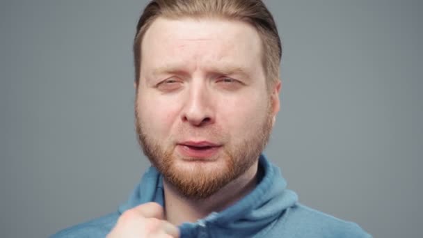 Video of blond man in blue sweatshirt in stuffy room, portrait — Stock Video