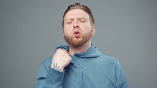 Video of man in blue sweatshirt in stuffy room, closeup — Stock Video