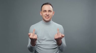 Boğazlı kazaklı genç adamın orta parmaklarını gösteren videosu.