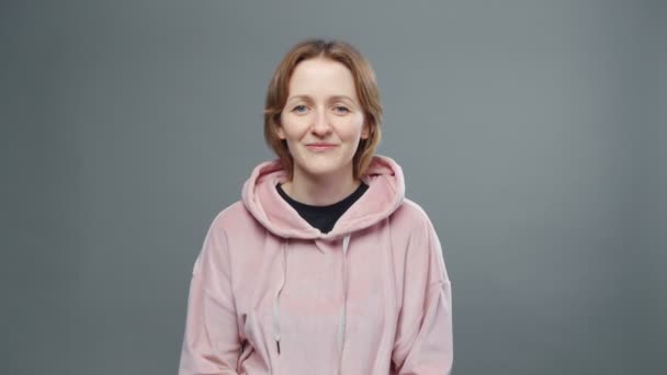 Schieten van jonge plottende vrouw in roze sweatshirt — Stockvideo