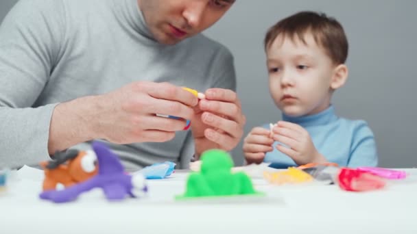 Tiro de pai e filho fazendo animais de plasticina — Vídeo de Stock