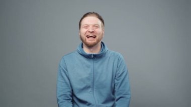 Mavi kazaklı, gülen sarışın adamın görüntüsü.