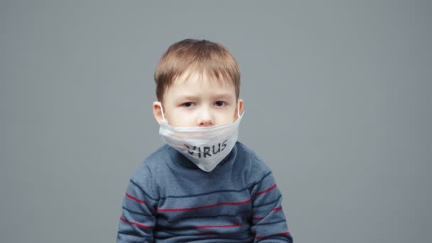 Střelba malého čtyřletého chlapce, který se zbavuje lékařské masky — Stock video