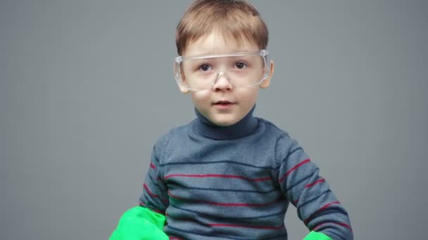 Маленький чотирирічний хлопчик в захисних рукавичках і окулярах — стокове відео