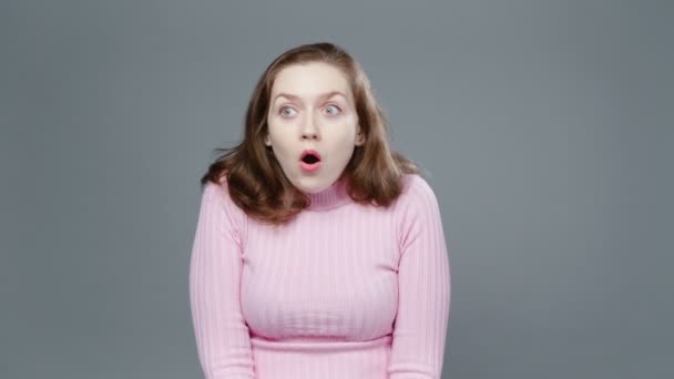 Видео изумленной женщины в розовой водолазке — стоковое видео
