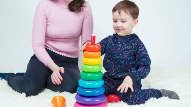 Mom and boy playing assembling pyramid — Stock Video