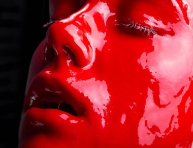 Kırmızı boyalı, ağzı açık bir kadının fotoğrafı.