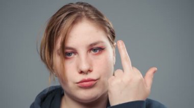 Orta parmak ve portre gösteren şişman bir kadının videosu.