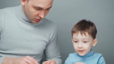 Baba ve oğulun plastikten hayvan yontması.