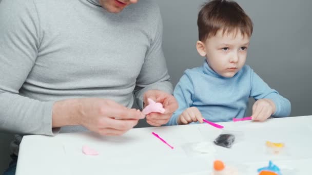 Father and son sculpting toys from plasticine — Stock Video
