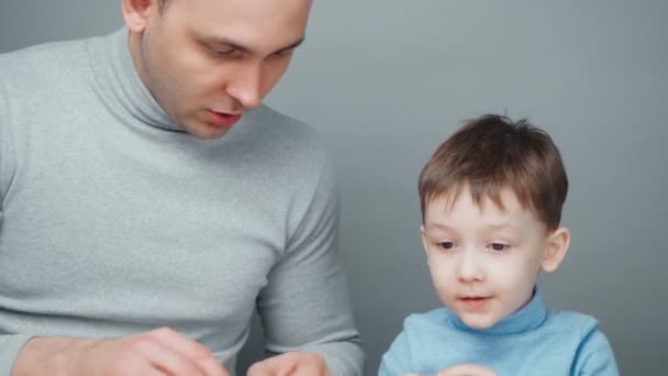 Skjutning av pappa och son som skulpterar djur av plast — Stockvideo