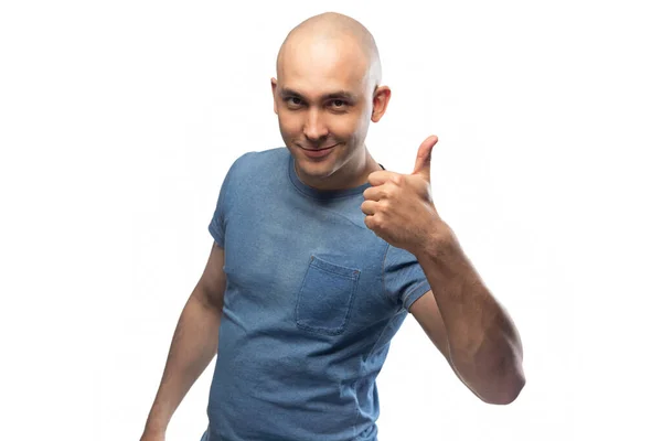 Mladý plešatý muž v modrém tričku ukazující palec — Stock fotografie