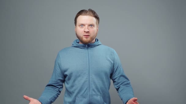 Video von überraschtem jungen Mann im blauen Sweatshirt — Stockvideo