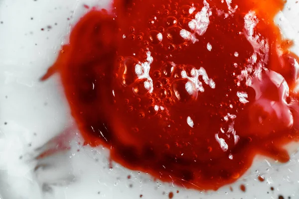 Image of sticky bubbled red liquid, close-up