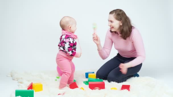 Tiro de mujer y niña jugando juguetes de colores — Vídeo de stock