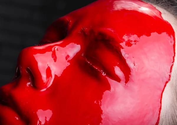 Постріл молодої дівчини з глянцевою червоною фарбою на обличчі — стокове фото