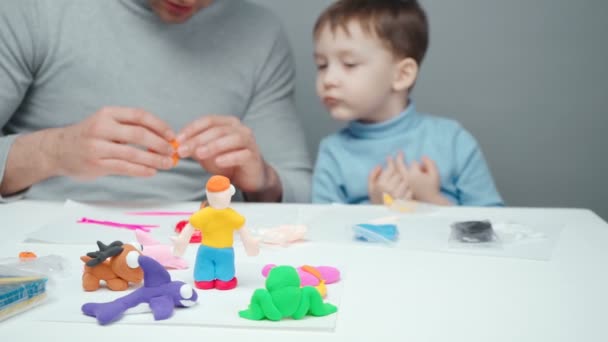 Schieten van vader en jongetje beeldhouwende dieren uit plasticine — Stockvideo