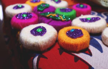 Bunlar Hindistan 'da gelişigüzel işler için hazırlanmış yün dekoratif eşyalar. Bunlar renkli yün teller şeklinde ve kaplanmış disklerdir..