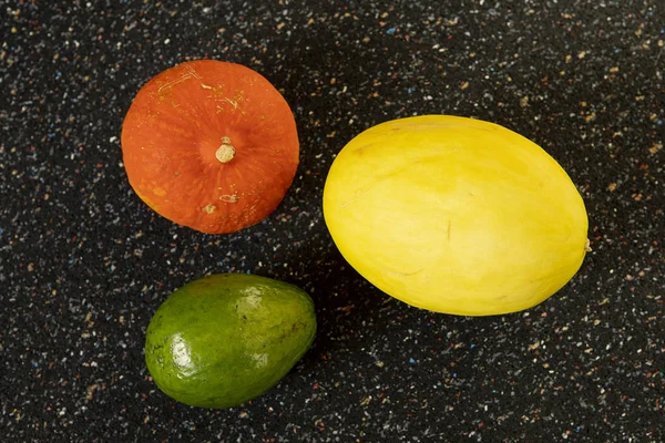 色彩斑斓的圆形蔬菜和水果 背景为深色大理石色 甜瓜和鳄梨静止不动 色彩简洁的抽象构图 食物艺术概念的抽象安排 — 图库照片