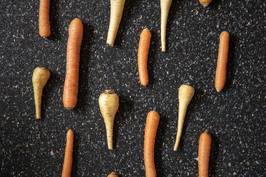 Kök sebzeler dikey desen, düz yiyecekler koyu arka planda yaşam soyut düzenlemesi. Havuç ve yaban havucu desenli. Neşeli yemekler. Kış çorbası malzemeleri..