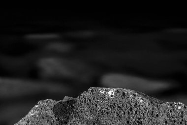 Siyah ve beyaz, tek renkli, soyut, arka plan, görünür dokuya sahip suya batırılmış taşların bileşimi. Karanlık ve kayalık arazideki sakinlik atmosferi. Kayalık detay, yakın plan.. 