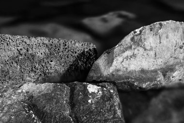 Siyah ve beyaz, tek renkli, soyut, deniz suyuna batırılmış desenli taşlar. Zen kayalıklarında durgunluk ve durgunluk atmosferi.