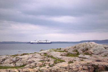 Nesodden / Norveç - 05 / 22 / 2019: Nesodden Peninsulala kıyısı boyunca büyük bir feribot akışı. Oslo Fjord 'da, kayalık sahilde bir yolcu gemisinde. Norveç 'te sevkiyat.
