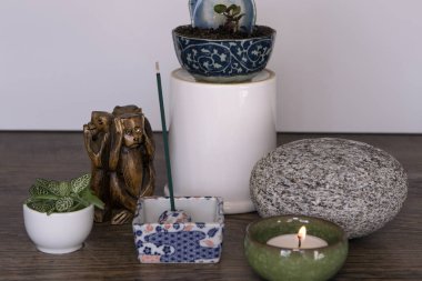 Ev mihrabı Seramik kapta yanan mum, tütsü çubukları, taş ve taze bitkiler. Ev kavramında ruhanilik. Günlük meditasyon rutini. Mini Zen Japon tarzı ev dekorasyonu. 