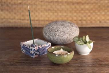 Burning incense, stone, fresh plant leaves, candlelight. Yoga, meditation equipment.