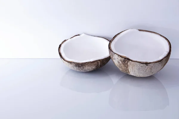 白いガラスの背景に反射と新鮮なオープンココナッツ コピースペース付きエレガントな新鮮なトロピカルココ — ストック写真