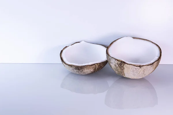 Dwie Połówki Kokosa Leżą Gładkim Jasnym Tle Tropikalny Owoc Neutralne — Zdjęcie stockowe
