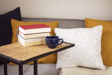 Masada kitaplar, bir fincan kahve ya da yastıklı rahat kanepeli çay. Evde kitap okumak, öğrenmek. Evde boş zaman aktiviteleri.