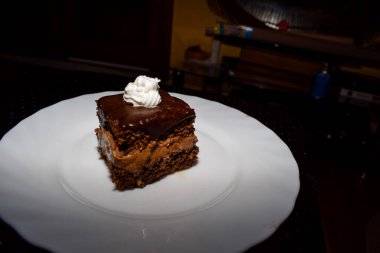 Üstünde krem şanti olan çikolatalı pasta.